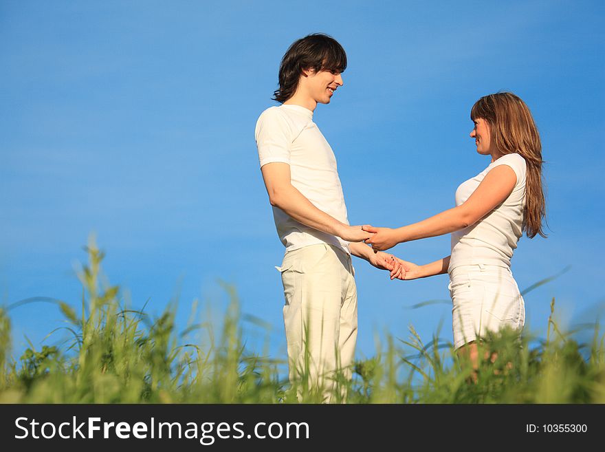 Girl and guy stand on grass having joined hands. Girl and guy stand on grass having joined hands