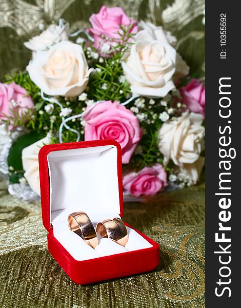 Two wedding rings in box and flowers