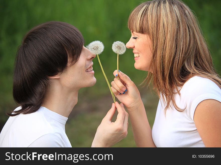 Young pair with dandelions in hands