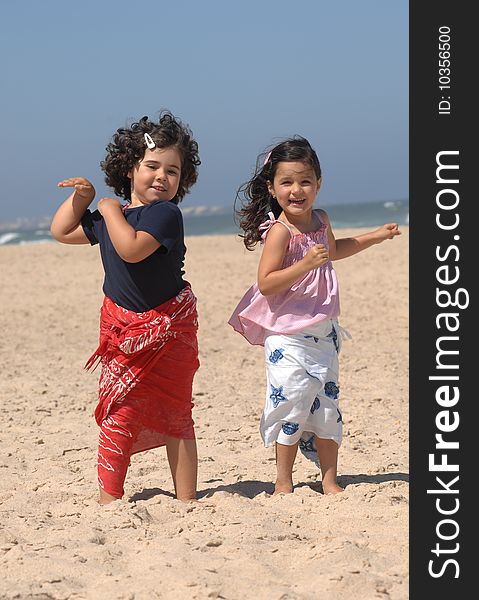 Cute little girls dancing on the beach