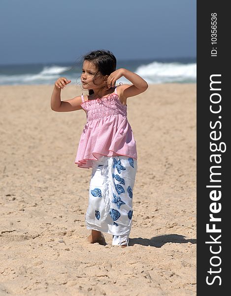 Cute little girl dancing on the beach