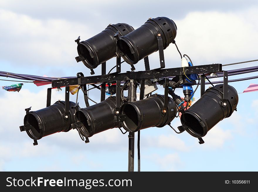 Six black spotlights at an outdoor concert