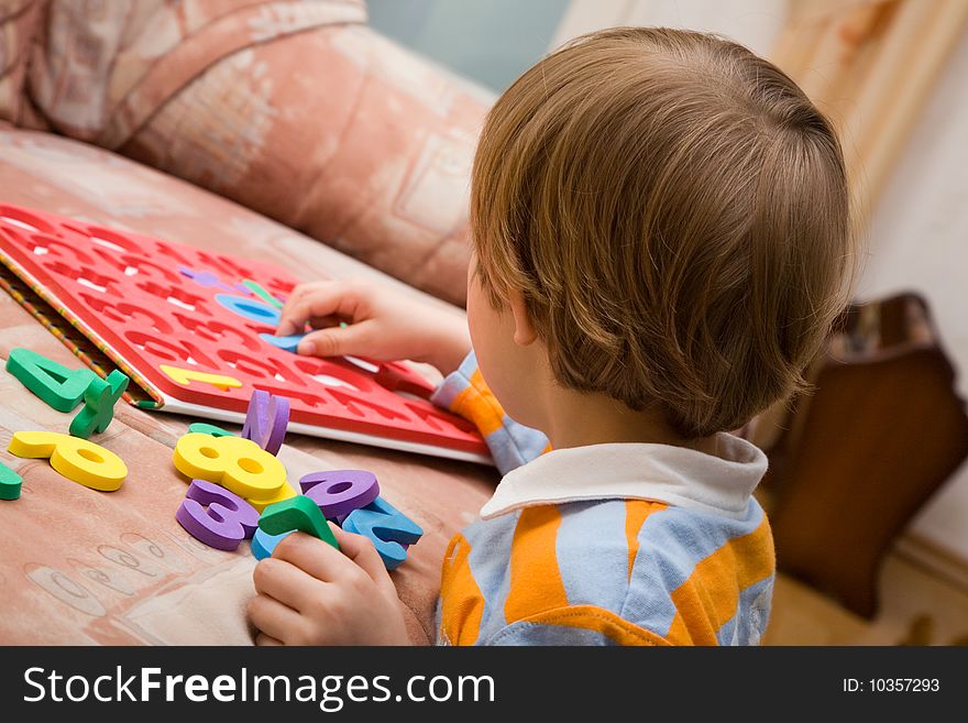 Young boy playing with plastic numbers. Young boy playing with plastic numbers.