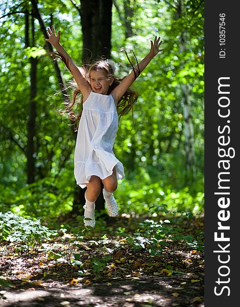 girl joyfully jumps in the wood