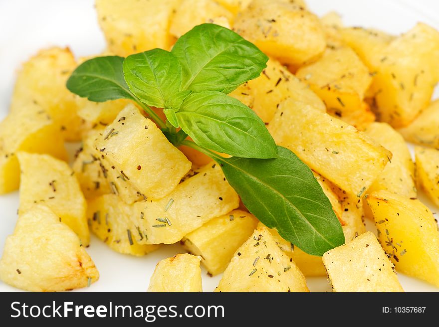 Fried potato with spices and fresh basil