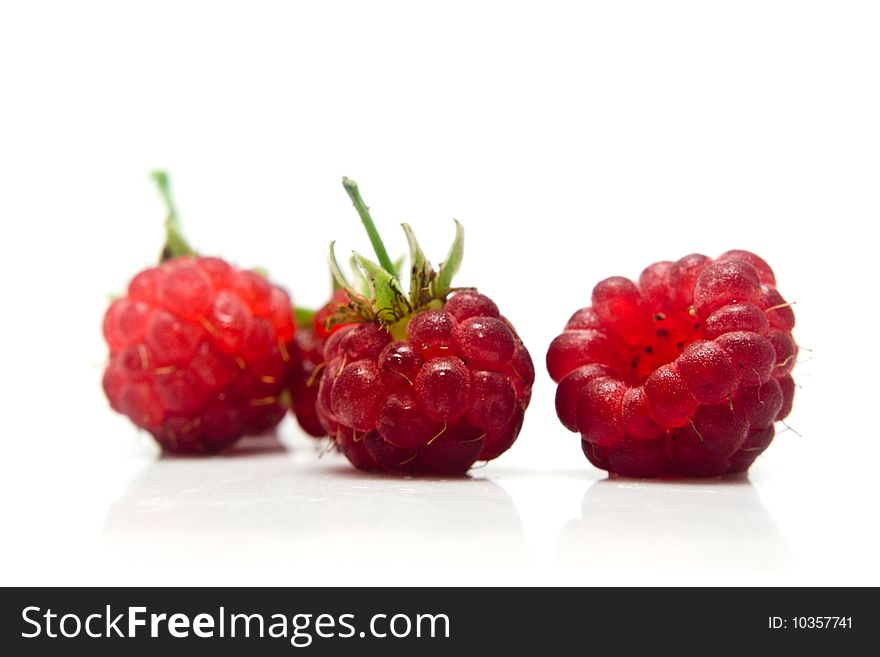 Three raspberries on a white background