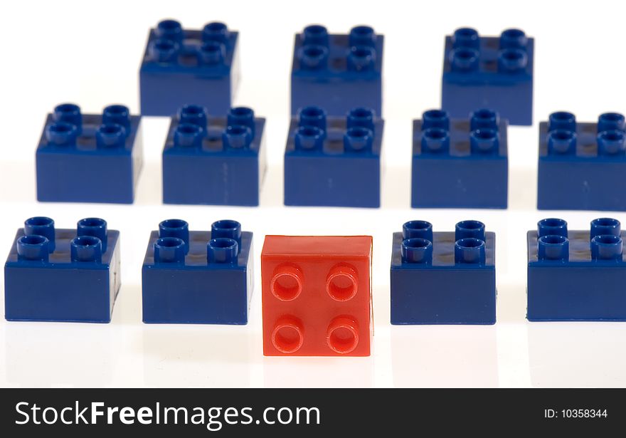 Battalion of toy blocks, one red block at head of blue block team. Battalion of toy blocks, one red block at head of blue block team