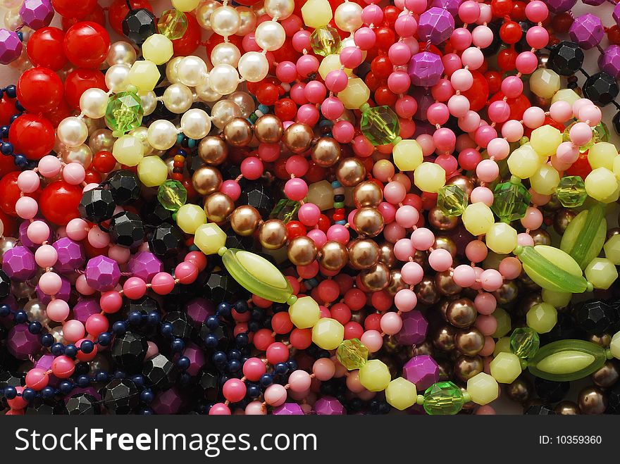 Many colored plastic necklaces background