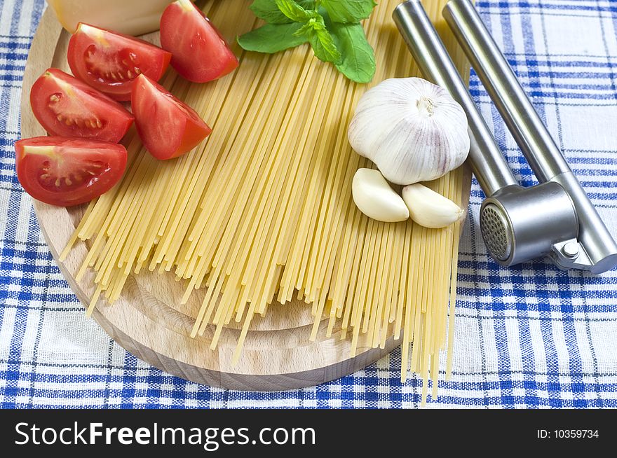 Raw Spaghetti with Red Tomatos and Garlic On Kitchen Table. Raw Spaghetti with Red Tomatos and Garlic On Kitchen Table