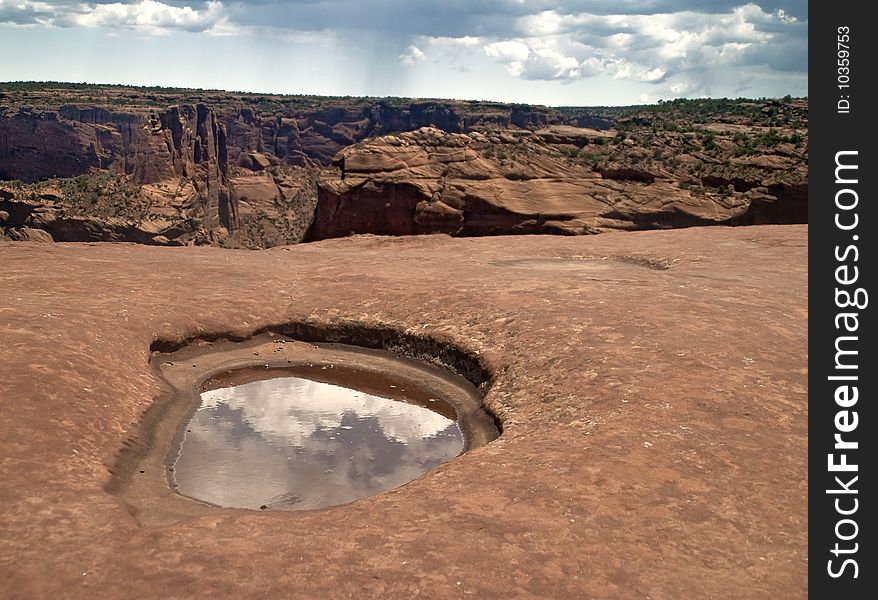 This is a rock basin with clouds reflected at Canyon de Chelly National Monument