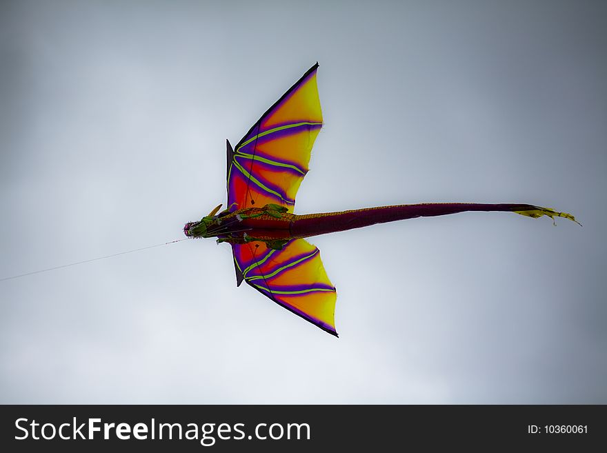 Dragon kite flying in a natural cloudy blue sky background