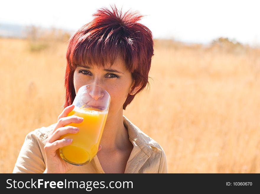 Woman tastes a glass of orange juice. Woman tastes a glass of orange juice