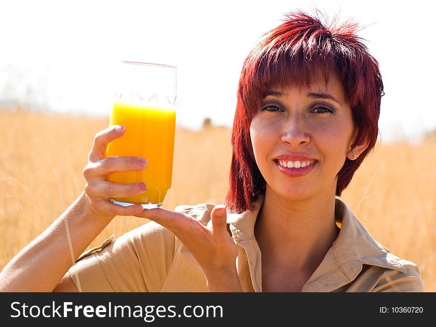 Woman happy with orange juice outdoors