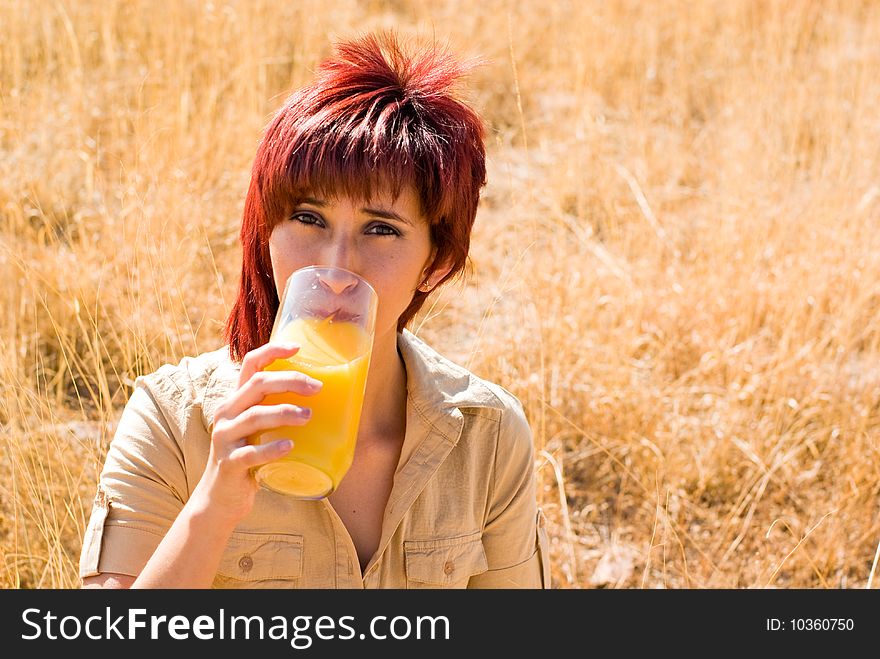 Latina woman drinks a glass of orange juice. Latina woman drinks a glass of orange juice