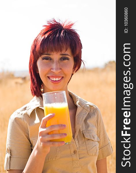 Woman happy drinking vitamin c glass of orange juice outside. Woman happy drinking vitamin c glass of orange juice outside