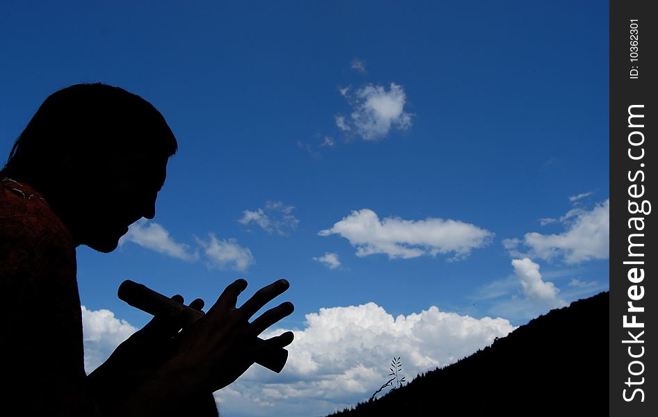 Man plays flute in mountains