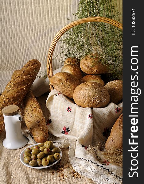 Tasty bread and green olives with grain and flowers. Tasty bread and green olives with grain and flowers