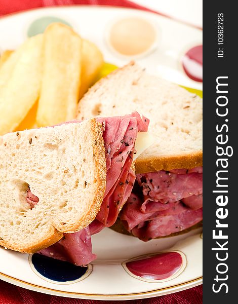 Pastrami sandwich with thick french fries and pickle. Pastrami sandwich with thick french fries and pickle