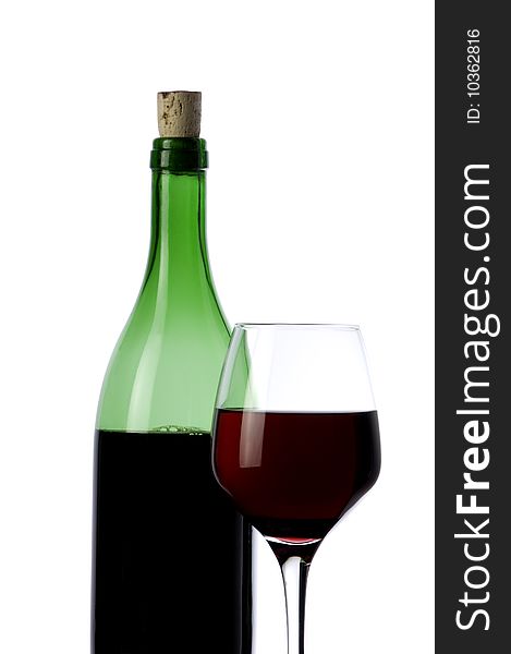 A glass and a bottle of red wine at warm background