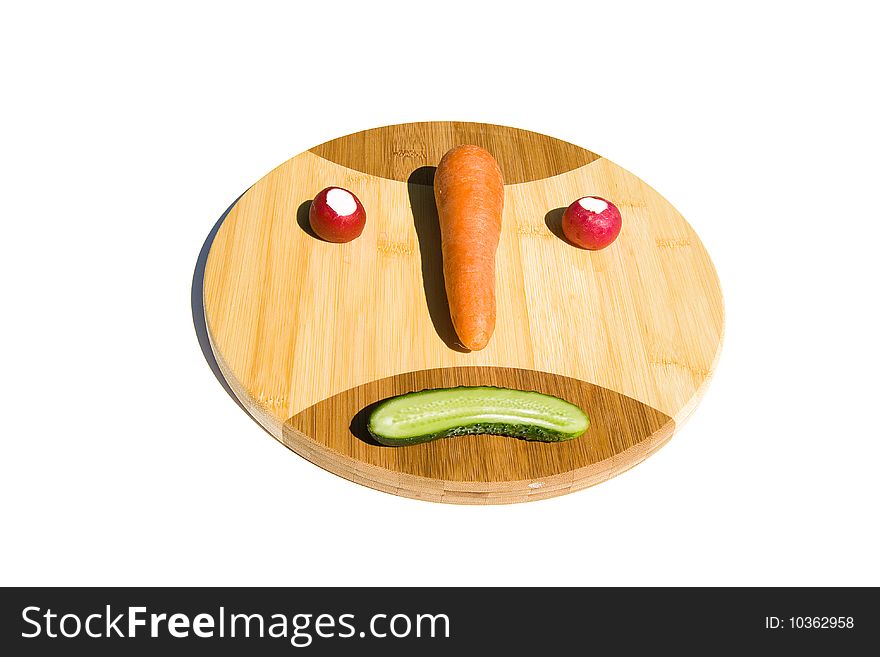 Smiley (emoticon) from vegetables on round cutting board. Smiley (emoticon) from vegetables on round cutting board