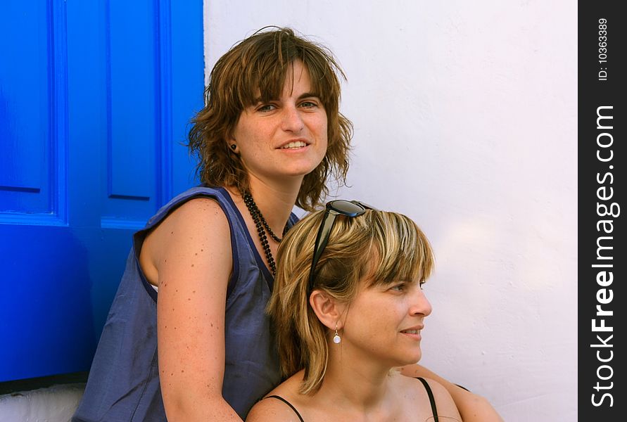 Two girls sitting at the door