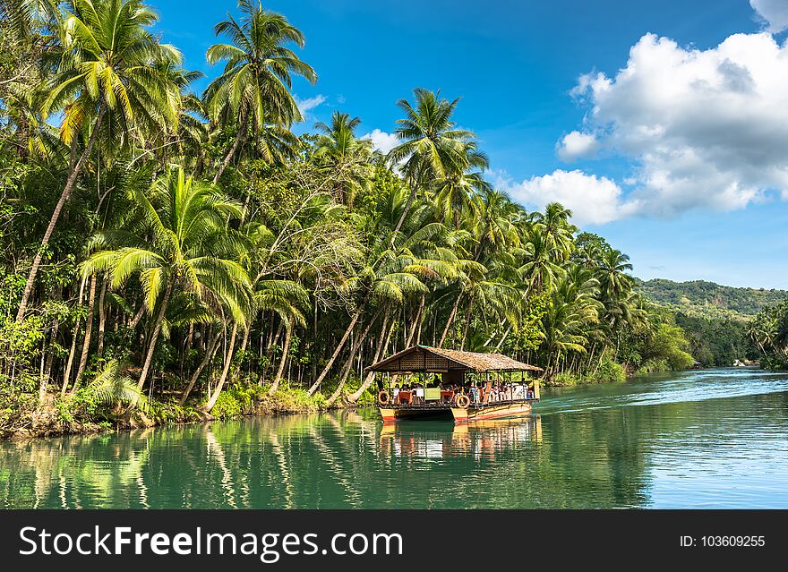 Traditional raft boat with tourists on a jungle green river