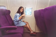 Asian Woman Is Sitting In The Airplane And Show Thumb Up Royalty Free Stock Image