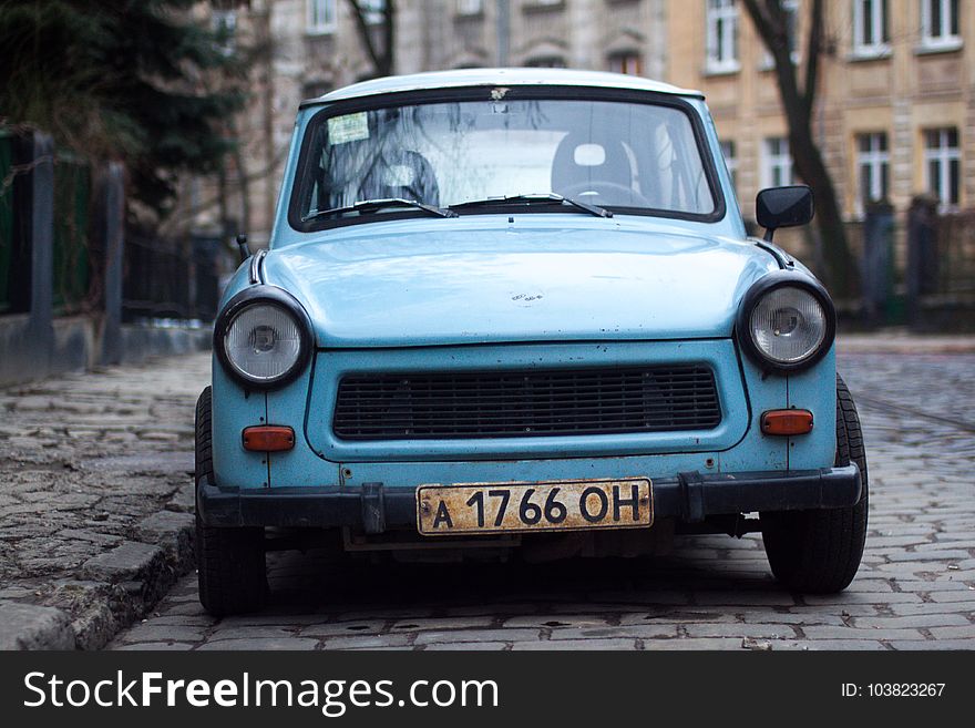 Classic Blue Car Parked Near Fence and Trees