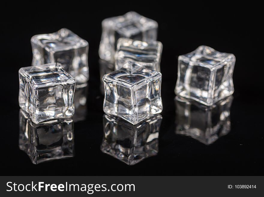 Ice cubes on the black background with reflections