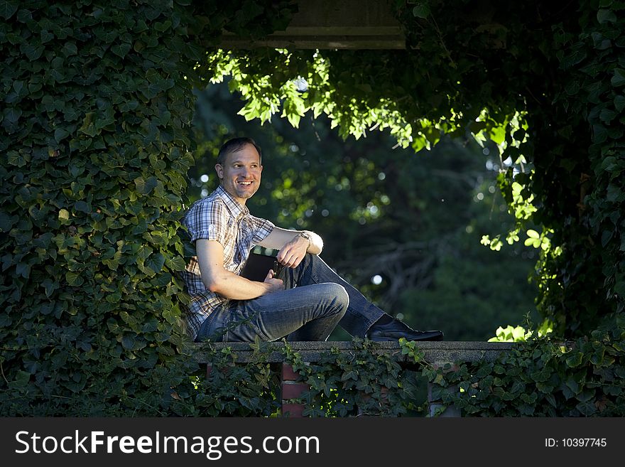 Happy man holding diary in a city park. Happy man holding diary in a city park