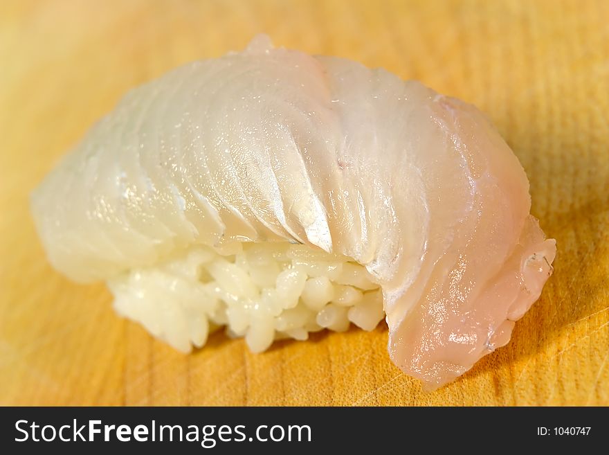 White fish sushi on a wooden board