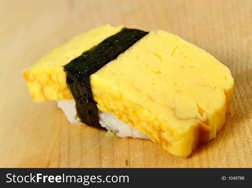 Tamago (Omelet) sushi on a wooden board. Tamago (Omelet) sushi on a wooden board