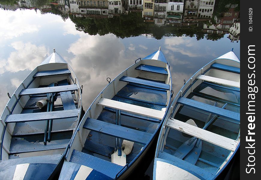 Three blue boats in a river. Three blue boats in a river