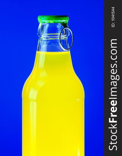 Glowing bottle of yellow drink on blue background. Glowing bottle of yellow drink on blue background
