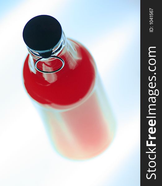 Glowing bottle of red drink on white-blue background, maybe a poison?. Glowing bottle of red drink on white-blue background, maybe a poison?