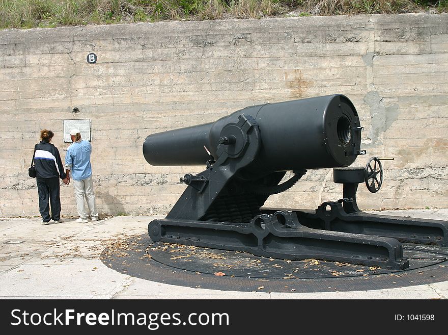 Large black cannon and couple at historic Fort Desoto, Florida. Large black cannon and couple at historic Fort Desoto, Florida