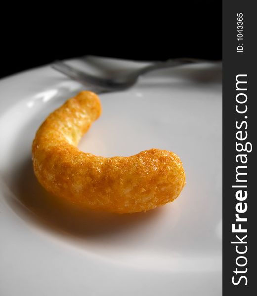 A bright orange cheese puff on a plate