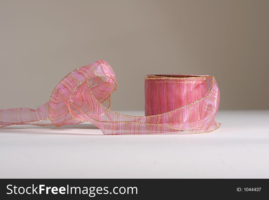 Spool of festive pink ribbon for general gift or holiday. Spool of festive pink ribbon for general gift or holiday