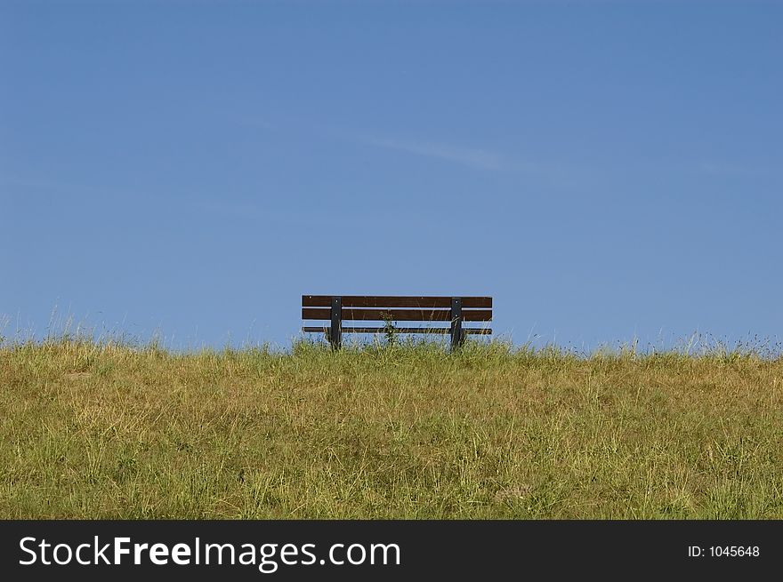 Bench on grass with blue sky