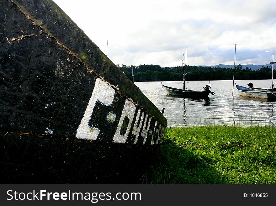 An old boat on the grass stranded to the shore.