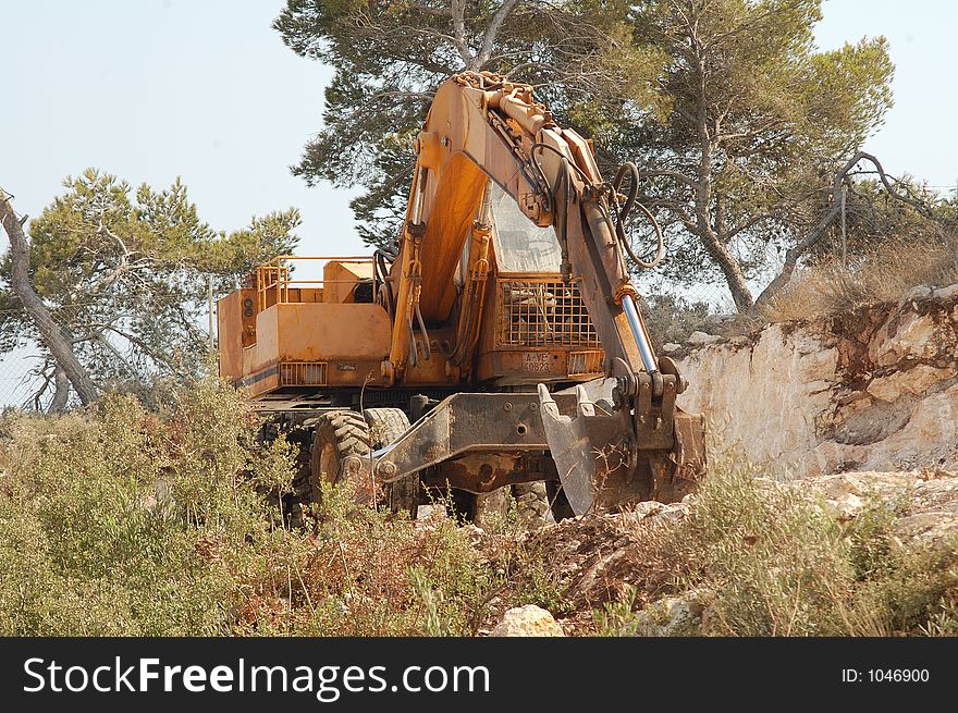 yellow digger with bucket resting on the floor