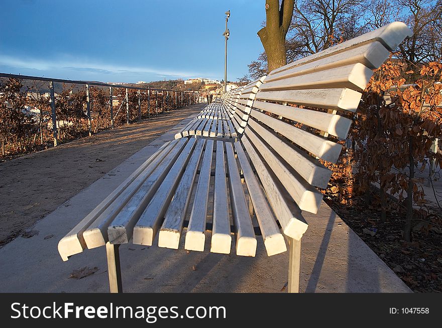 A row of white benches in autumn