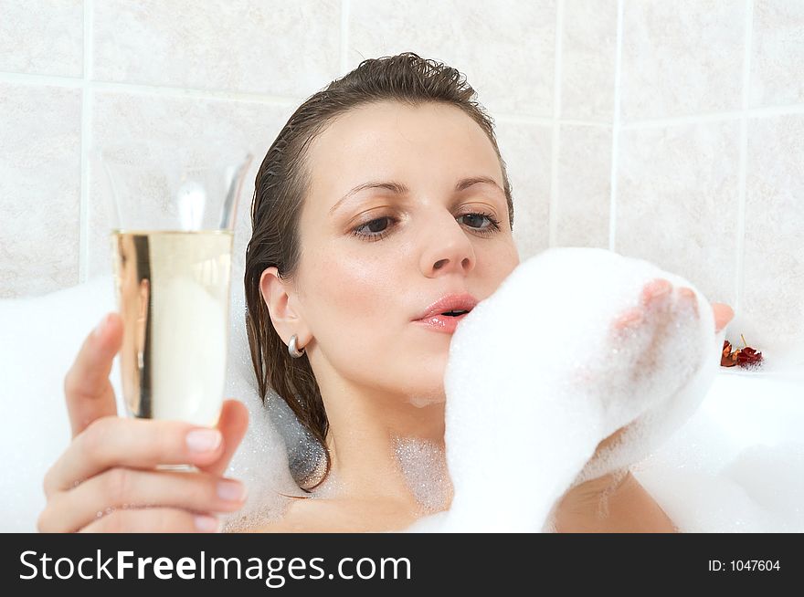 Girl in a bath drinking wine