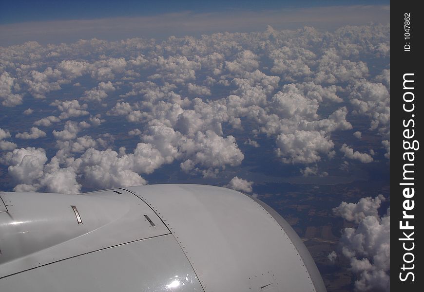 Great aerial shot of clouds, including the corner tip of the plane engine. Great aerial shot of clouds, including the corner tip of the plane engine