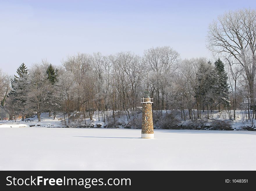Lighthouse on frozen over winter pond. Lighthouse on frozen over winter pond.