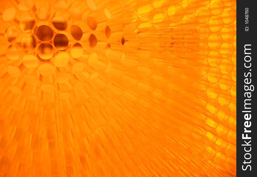 A wall made of small pieces of orange straw that defracts light as people walk along it, taken at the IIT student center
