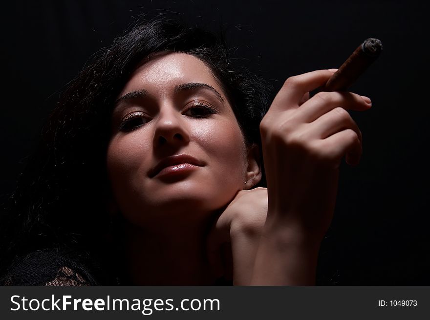 Brunette girl smoking, on black background