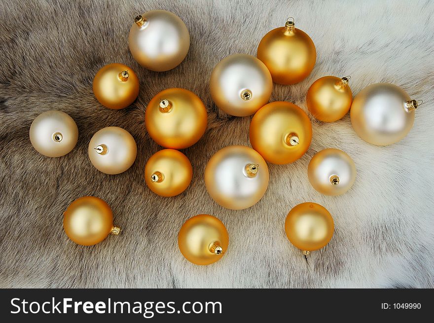 Golden and white X-mas balls on reindeer fur coat. Golden and white X-mas balls on reindeer fur coat