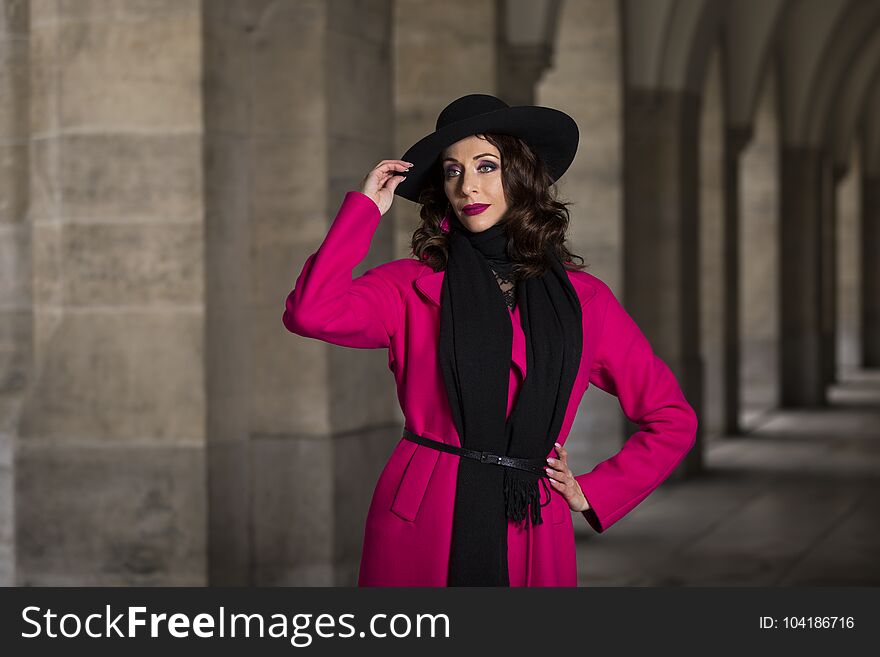 Lifestyle portrait of a woman with pink coat and black hat. Lifestyle portrait of a woman with pink coat and black hat