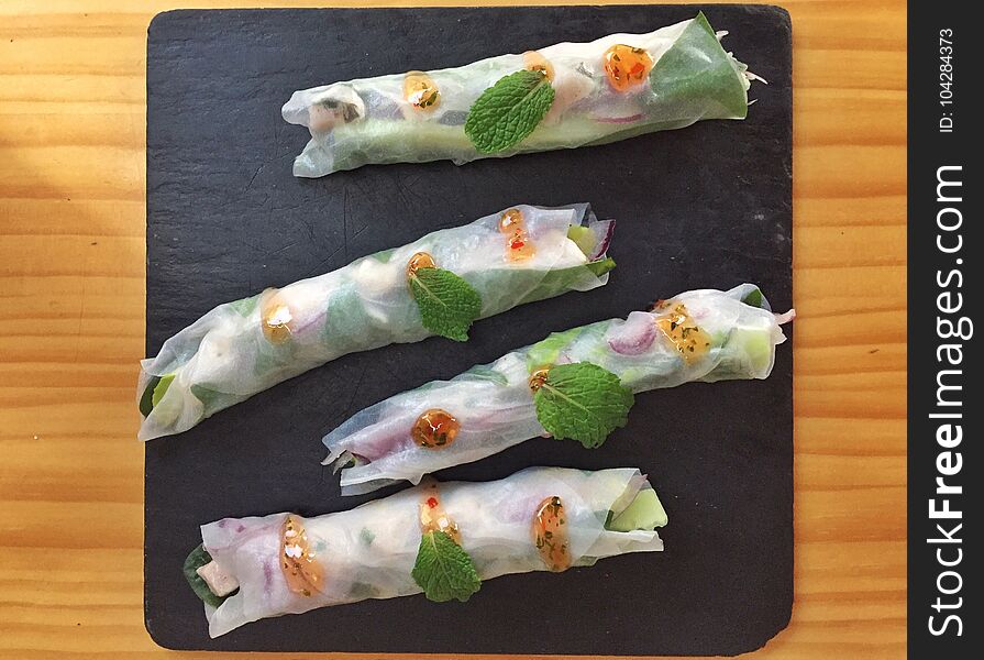 Delicious vegetarian wraps with vegetables on ceramic plate.